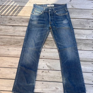 Levi's 512 Bootcut jeans blå W30 L32 - Säljer ett par klassiska Levi's 512 Bootcut jeans i blå denim. Jeansen har fem fickor, snygga slitningar och kontrastsömmar. Bootcut-modell med normal passform och ikonisk läderpatch bak. Perfekta för dig som gillar retrovibbar och tidlös stil.