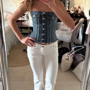 Jeans topp - Säljer en snygg tubtopp i jeans med silverfärgade knappar framtill och fransad nederkant. Toppen har två dekorativa bröstfickor och markerade sömmar som ger en cool och trendig look. (Lägger ut igen) 💓