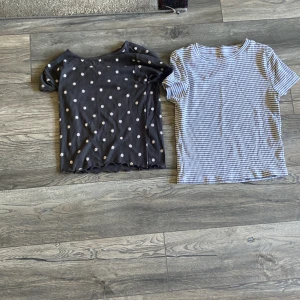 Svart blommig ribbad topp Primark - Svart ribbad topp från Primark med söta vita blommor över hela och vågig kant nertill. Kortärmad och stretchig, perfekt för dig som gillar en söt och chill stil. Passar dig som vill ha något enkelt men ändå med lite extra detalj. Två för 50