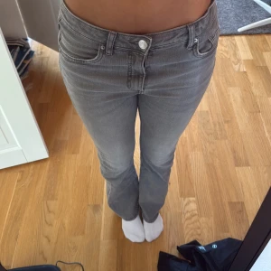 Grå bootcut jeans från LAB Industries - Snygga grå jeans från LAB Industries i bootcut-modell. Jeansen har klassisk femficksdesign, hyfsad låg midja och är tillverkade i mjukt bomullsmaterial med lite stretch. Perfekta för dig som gillar en stilren look med lite utsvängda ben.