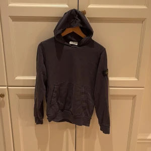 Svart hoodie  - Svart hoodie  med klassisk logga på vänster ärm. Tröjan har huva, känguruficka framtill och är tillverkad i mjuk bomull. Perfekt för dig som gillar streetwear och vill ha en stilren look.