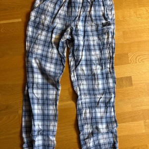 Pyamsbyxor från Björn Borg - Säljer ett par pyjamasbyxor från Björn Borg i blått och vitt rutigt mönster. Byxorna  är perfekta för chill dagar hemma. Mjukt material och avslappnad passform.