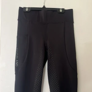 Svarta ridleggings från Kingsland - Svarta ridleggings från Kingsland med tight passform. Byxorna är helskodda med praktiska fickor på sidorna och logga på låret. Endast använda en gång. Säljer då de är för små. Storlek S men sitter mer som xs.💗
