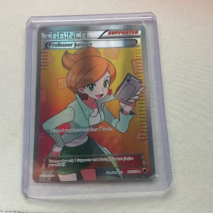 Professor Juniper - Cool och färgstark Pokémon-samlarbok med Professor Juniper från Plasma Freeze-serien! Perfekt för dig som älskar Pokémon och vill ha en unik supporter-kort i din samling. Holografisk design som verkligen sticker ut!