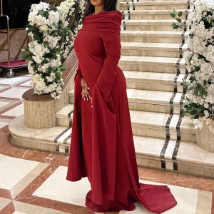 Vinröd långklänning med offshoulder - Säljer en vinröd långklänning med offshoulder och långa, vida ärmar. Klänningen har en elegant draperad överdel och figurnära passform upptill. Klänningen är skräddarsydd i Egypten! 