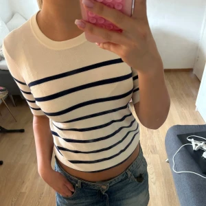 Randig kortärmad tröja i bomull - Snygg vit tröja med marinblå ränder och korta ärmar. Tröjan har en klassisk rund halsringning och är gjord i mjuk bomull. Tröjan är från Zara i storlek S💗