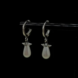 Silver 925 örhängen med pärldroppar - Snygga örhängen i silverfärg med droppformade vita pärlor och små stjärndetaljer upptill. Silverfärg 925