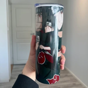 Termosmugg med anime-design - Snygg termosmugg med motiv från en populär anime. Muggen har en mörk design med karaktärer i fokus och en röd detalj. Perfekt för att hålla drycken varm eller kall i timmar. Vid önskemål så kan man välja valfria bilder/texter. muggarna är nya och oanvända. sugrör tillkommer.