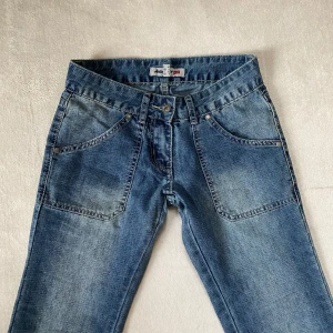 Lågmidjade bootcut-jeans - Snygga blå jeans från Jennyfer Denim med låg midja i storlek 32, passar xxs. Innerbenslängd är 85 cm och midjemåttet (rakt över) är 35 cm. Köpte dessa på Vinted men de var för små för mig. 💕