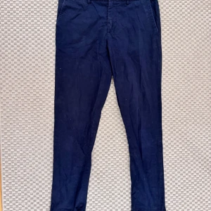 Mörkblå chinos från J. Lindeberg - Snygga mörkblå chinos från J. Lindeberg i en klassisk design. Byxorna har en normal passform. Storlek 32/32