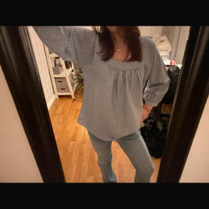 Randig blus med trekvartsärm - Säljer en stilren randig blus i blått och vitt med trekvartsärmar. Blusen har en lös passform och en rundad halsringning som ger en avslappnad look. Perfekt för både vardag och lite finare tillfällen🤍 storleken är XL men sitter som M