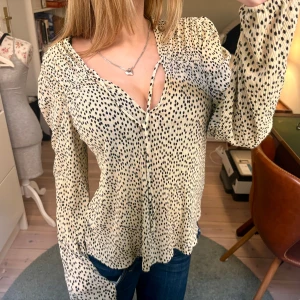 Superfin blus från Mango  - Säljer den här superfina beiga/vita blusen med svarta prickar på från Mango i storlek XS. Blusen har aldrig blivit använd men har däremot klippt bort prislappen. Perfekt nu inför våren! 