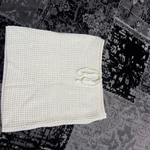 Vit stickad kjol - Säljer en mysig vit stickad kjol med knytband i midjan. Perfekt för stranden, ger en stilren look. Kjolen har en fin textur och är enkel att matcha med olika toppar.