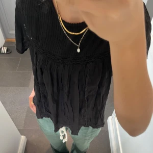 Svart topp med spets - Svart blus från Mango i storlek M, passar även S och skulle säga XS. Fint skick. Använd gärna köp nu!