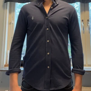 Mörkblå skjorta från Ralph Lauren - Mörkblå skjorta från Ralph Lauren i feather weight mesh material. Den är i storlek S (passar folk under 180) och är i skick 9/10