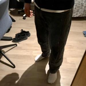 Woodbird jeans  - Säljer ett par svart-grå jeansbyxor med en klassisk straight passform. Byxorna har en midwaist design och är tillverkade i jeansmaterial. De är riktigt sköna att ha på sig.