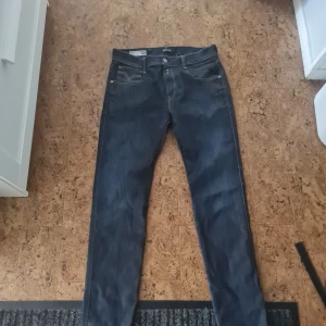 Mörkblå jeansbyxor Replay - Snygga mörkblå jeansbyxor med en klassisk straight passform. Perfekta för en avslappnad stil. De har en dragkedja och knappar framtill. Ett måste i garderoben för alla jeansälskare! Stl 30/32