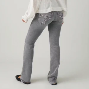 Grå bootcut Jeans  - Snygga grå jeans med bootcut passform och broderade detaljer på bakfickorna. Endast använd fåtal gånger 