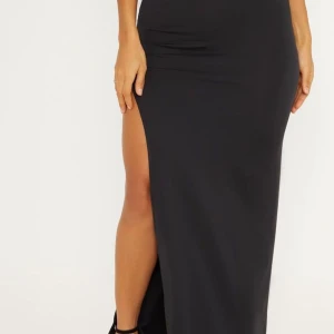 Svart långklänning med slits - Snygg svart långklänning med  slits på ena sidan. Kjolen har en figurera passform och är perfekt för festliga tillfällen eller under sommaren. Enkel och oanvänd kjol som va för liten på mig/ stl M, kontakta via frågor.