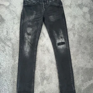Svarta Dondup jeans  - Svarta Dondup jeans med slitningar. Storlek 30. Passform George skinny fit.