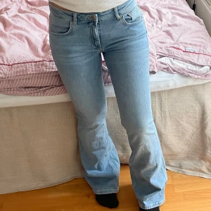 Ljusblå bootcut jeans från Lager 157 - Säljer ett par ljusblå jeans från 157 med klassisk femficksdesign och bootcut passform. Jeansen har normalhög midja.