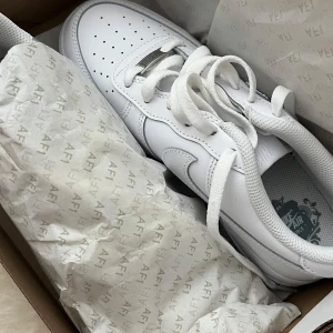 Nike Air Force 1 helvita sneakers - Säljer nu mina helt nya helvita Nike Air Force 1 i storlek 39. Skitsnygga och passar till alla outfits och speciellt nu till sommaren. köpta för 1499kr och säljer för 1000 då de somsagt är helt nya💞skulle säga att de passar 38-40.