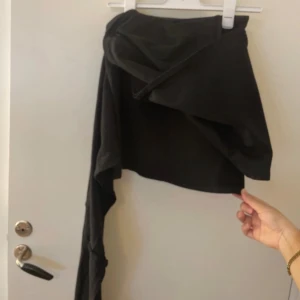  kjol med rosett  - Säljer en svart kjol med en rosett. Aldrig använd prislapp kvar!