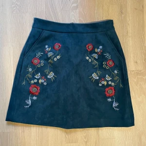 Broderad A-linjekjol/ Embroidered A-line Skirt - Broderad A-linjekjol med fickor, Gott Skick! Välvårdad och sparsamt använd. Midjemått: 68 cm (resår bak) | Kjollängd: 41 cm | Storlek: M Finns för upphämtning i Kista, Stockholm eller leverans enligt överenskommelse.