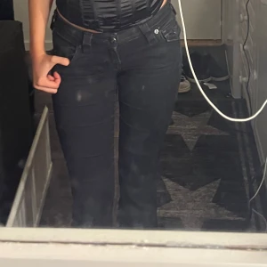 Svarta bootcut True Religion jeans - Säljer ett par svarta bootcut jeans. Jeansen har en snygg passform som sitter tajt upptill och släpper ut vid benen. Perfekta till sneakers eller boots. Jeansen är väldigt lågmidjade och är från True religion och skulle behöva en svart tvätt så är dem som innan igen. Säljer då jag tröttnat på dem och har flertal andra svarta jeans. Dem ör köpta för 1500 orginal. Pris kan sänkas vid snabb affär. Modellen Joey Low waist Flare