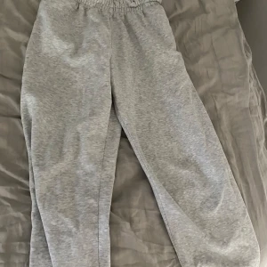 Grå mjukisbyxor från Weekday - Säljer ett par grå mjukisbyxor från Weekday i storlek S. Byxorna har resår i midjan och är tillverkade i mjuk bomull☺️ lite korta på mig som är 170:)