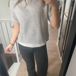 Ljusgrå stickad kortärmad tröja - Mysig ljusgrå stickad tröja med korta ärmar och rak passform. Perfekt för lager-på-lager och enkel att matcha med olika outfits. Mjuk och skön mot huden, från gina tricot.