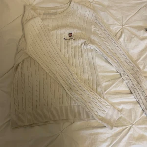 Vit kabelstickad tröja från Bondelid - Säljer en klassisk vit kabelstickad tröja från Bondelid i storlek XS. Tröjan har rund halsringning, långa ärmar och ett litet broderat märke på bröstet. Perfekt för en stilren och tidlös look. Har lite fläckar (bild 4 o 5). Hör av dig vid funderingar!
