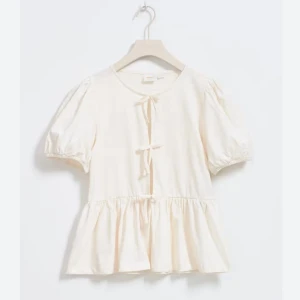 Vit blus med knyt från Gina Tricot - Söt vit blus från Gina Tricot med korta puffärmar och rosetter framtill. Blusen har en volang nedtill som ger en luftig och feminin känsla. Perfekt för vår och sommar! Den är använd ca 2 gånger. Pris går att diskuteras💓💓