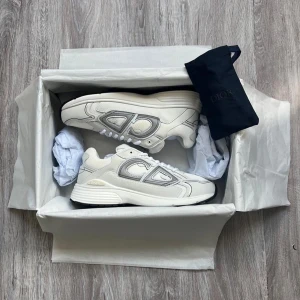 Dior B30 - Säljer ett par fräscha vita Dior B30s med snygga silverdetaljer på sidorna. Perfekta för dig som vill ha en stilren och exklusiv look.