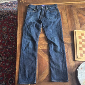 Mörkblå straight fit jeans från Ralph Lauren Purple Label - Säljer ett par klassiska mörkblå jeans från Ralph Lauren Purple Label, tillverkade i Italien. Jeansen har raka ben, fem fickor och snygga kontrastsömmar. Perfekta för dig som gillar tidlös stil och hög kvalitet. Selvedged Denim, sitter straight/lite slim såsom Levis 501. Storlek 32/34. Riktigt fina o knappt använda.