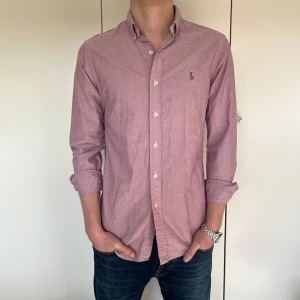 Rosa polo ralph lauren skjorta - Riktigt klassig skjorta från polo som passar perfekt att ha till sommaren och våren. Skjortan är inte helt felfri men är nästan som ny i skicket. Den är M men passar också S.