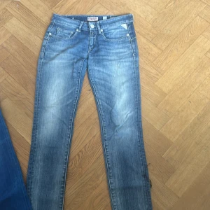 Blå jeansbyxor från Replay - Snygga blå jeansbyxor från Replay med en klassisk femficksdesign. De har en straight passform och är perfekta för en avslappnad stil. Jeansen har en lätt tvättad look som ger dem en cool och trendig känsla.