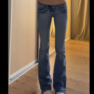 Blå bootcut jeans från E-Style - Lågmidjade bootcut jeans. Midjemått: 35 och innerbenslängd: 81