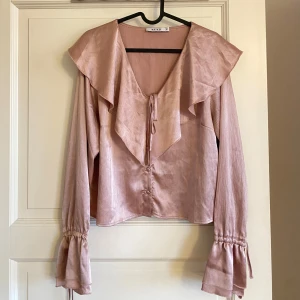 Fin blus!  - Jättesöt ljusrosa blus från NA-KD 💞 Den är använd men har inte märkt av några synliga detaljer på det. Blusen är relativt kort och i strl 38. Det är bara att fråga om du har några funderingar.
