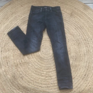 Svarta slim jeans från Jack & Jones - Snygga svarta slim jeans från Jack & Jones, modell Glenn. Perfekta för en stilren look med en smal passform. Klassisk design med fem fickor och knappgylf.
