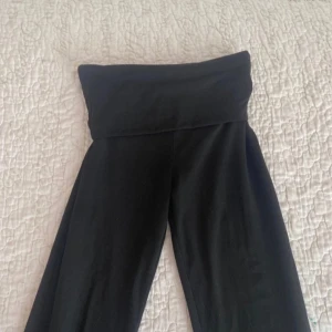 Svarta byxor med hög midja - Snygga svarta byxor med hög midja och vida ben. Perfekta för en stilren look. Byxorna har en enkel design utan mönster eller detaljer.