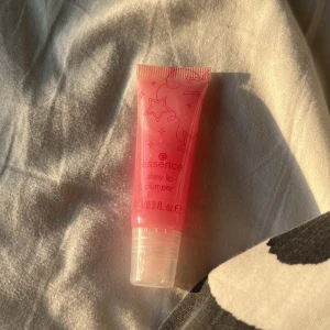 Essence Shiny Lip Plumper - Säljer en Essence Shiny Lip Plumper i en söt rosa tub. Den ger en glansig finish och en fylligare look till läpparna❤️ Perfekt för att ge lite extra volym och glans✨