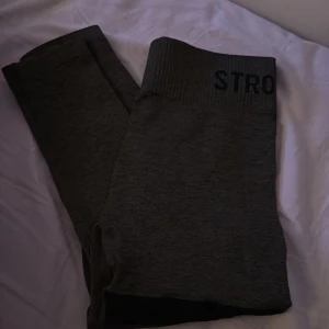 Mörkgröna stronger tights - Snygga gröna leggings med svarta ränder runt låret. Perfekta för träning eller en avslappnad dag hemma. De har en bred resår i midjan för extra komfort. Storlek xs/s