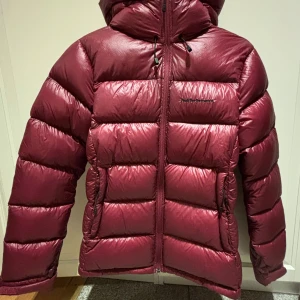 Vinröd dunjacka från Peak Performance - Säljer min fina Peak jacka! Väldigt fint skick, då den är sparsamt använd. Storlek S, nyköpt för 3700. Mitt pris: 1000