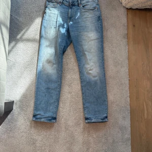 Ljusblå jeansbyxor - Snygga ljusblå jeansbyxor med en klassisk femficksdesign. De har en rak passform och är perfekta för en avslappnad stil. Byxorna har en dragkedja och knapp framtill.