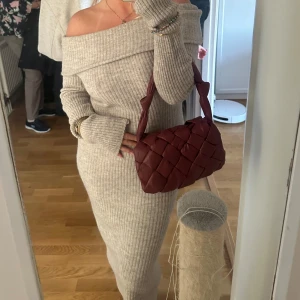 Grå offshoulder klänning - Snygg grå offshoulder klänning i ribbat material. perfekt för en stilren look med långa ärmar och en kroppsnära passform. klänningen är i en neutral färg som passar till många tillfällen. använd ca 1 gång så precis som ny!!!