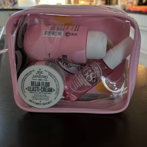 Hudvårdspaket från Sol de Janeiro - Säljer ett hudvårdspaket från Sol de Janeiro i en rosa necessär. Innehåller Beija Flor Elasti-Cream och andra produkter i matchande rosa förpackningar. Perfekt för att hålla huden återfuktad och doftande gott.
