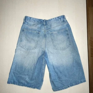 Bershka Baggy jorts - Säljer ett par snygga blå baggy jorts från Bershka. Använda lite förra sommaren, sedan legat i garderoben. Bra skick, inga hål eller fläckar. Skick 7-8/10 enligt mig. En bälteshälla är lite sliten från att jag hängt nycklar där, men det påverkar inget och syns knappt. Storlek EUR 34, passar ungefär 165-170 cm beroende på midjans storlek. Be om mått om du vill vara säker på att de passar. De passade mig när jag var 165-170 cm och hade 28-29 i Waist. Köptes för 500 kr och säljs för 200. Mvh Carl 