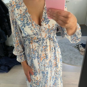 Blommig klänning med volangdetaljer - Säljer en vacker blommig klänning med volangdetaljer och v-ringning. Klänningen är köpt från plick därav vet jag inte vad den kommer ifrån då lappen är av. Skriv för fler bilder eller frågor❤️ 