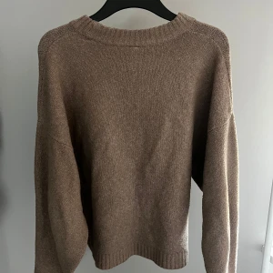 Beige stickad tröja från Nelly - Mysig beige stickad tröja från Nelly i storlek XS. Perfekt för kyliga dagar med sin mjuka och bekväma passform. Tröjan har långa ärmar och en rund halsringning med ribbade detaljer.